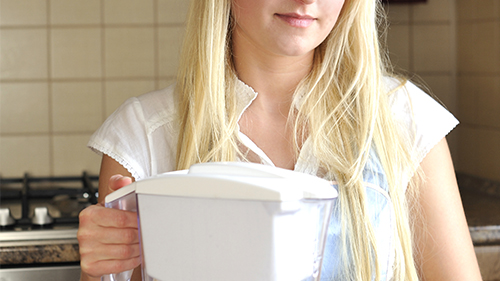 ragazza che tiene in mano una caraffa filtrante